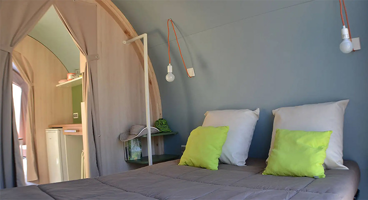 Lit double dans la chambre de la tente ecolodge du camping Le Port de Plaisance à Bénodet en Bretagne