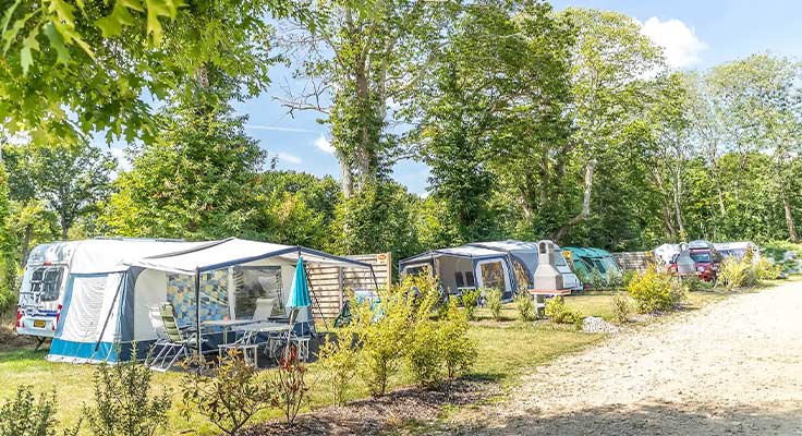 Allée d'emplacements avec caravanes et tentes au camping Le Port de Plaisance à Bénodet en Bretagne