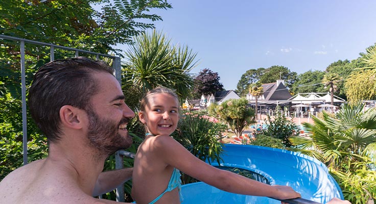 Un père et sa fille sur un toboggan du parc aquatique du camping Le Port de Plaisance à Bénodet